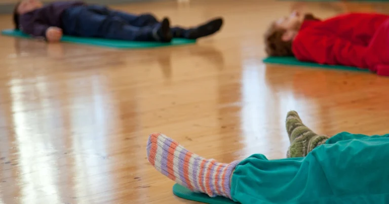 Students resting on mats on a wooden floor during an Awareness Through Movement class taught by Malcolm Manning at ISLO (Itä-Suomen Liikuntaopisto) in Joensuu, Finland