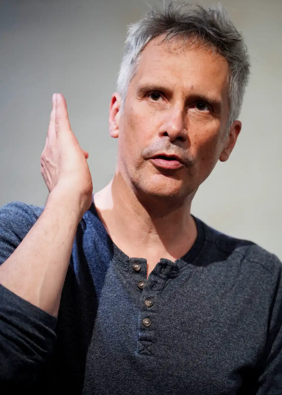 Portrait of Malcolm Manning gesturing with one hand as he speaks