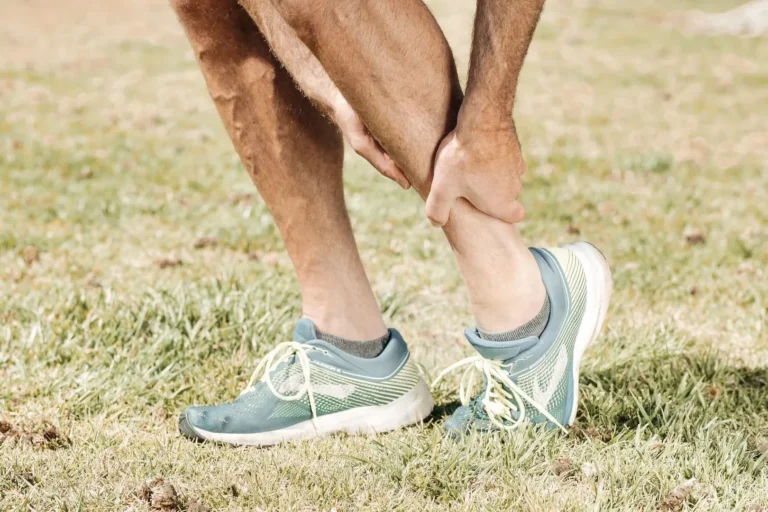 Man massaging his calf outdoors