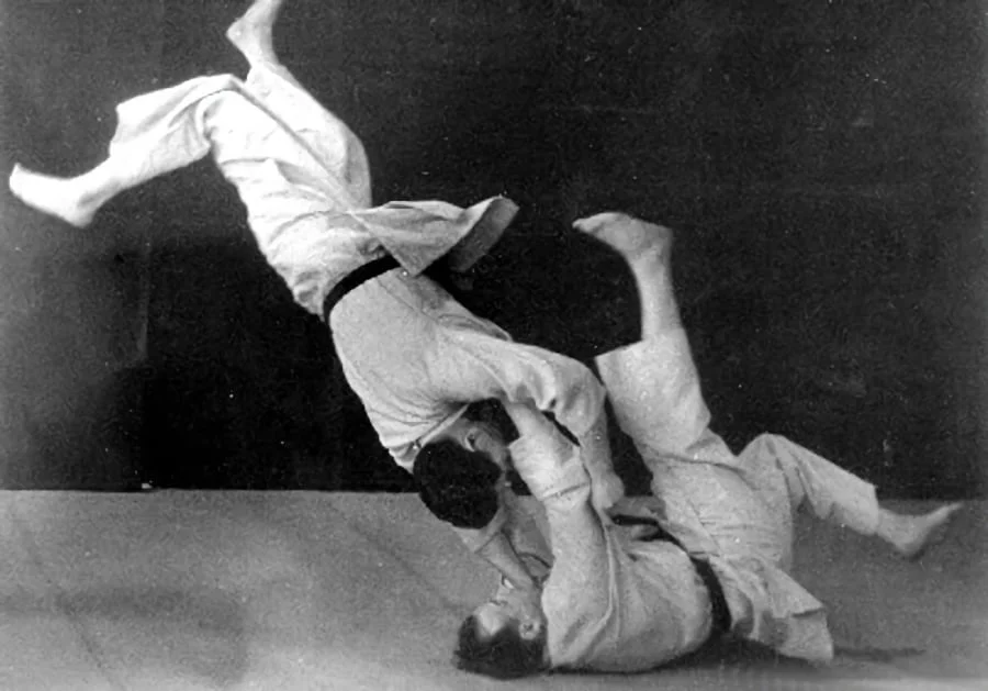 Black-and-white photo of Moshe Feldenkrais throwing a partner in a judo demonstration