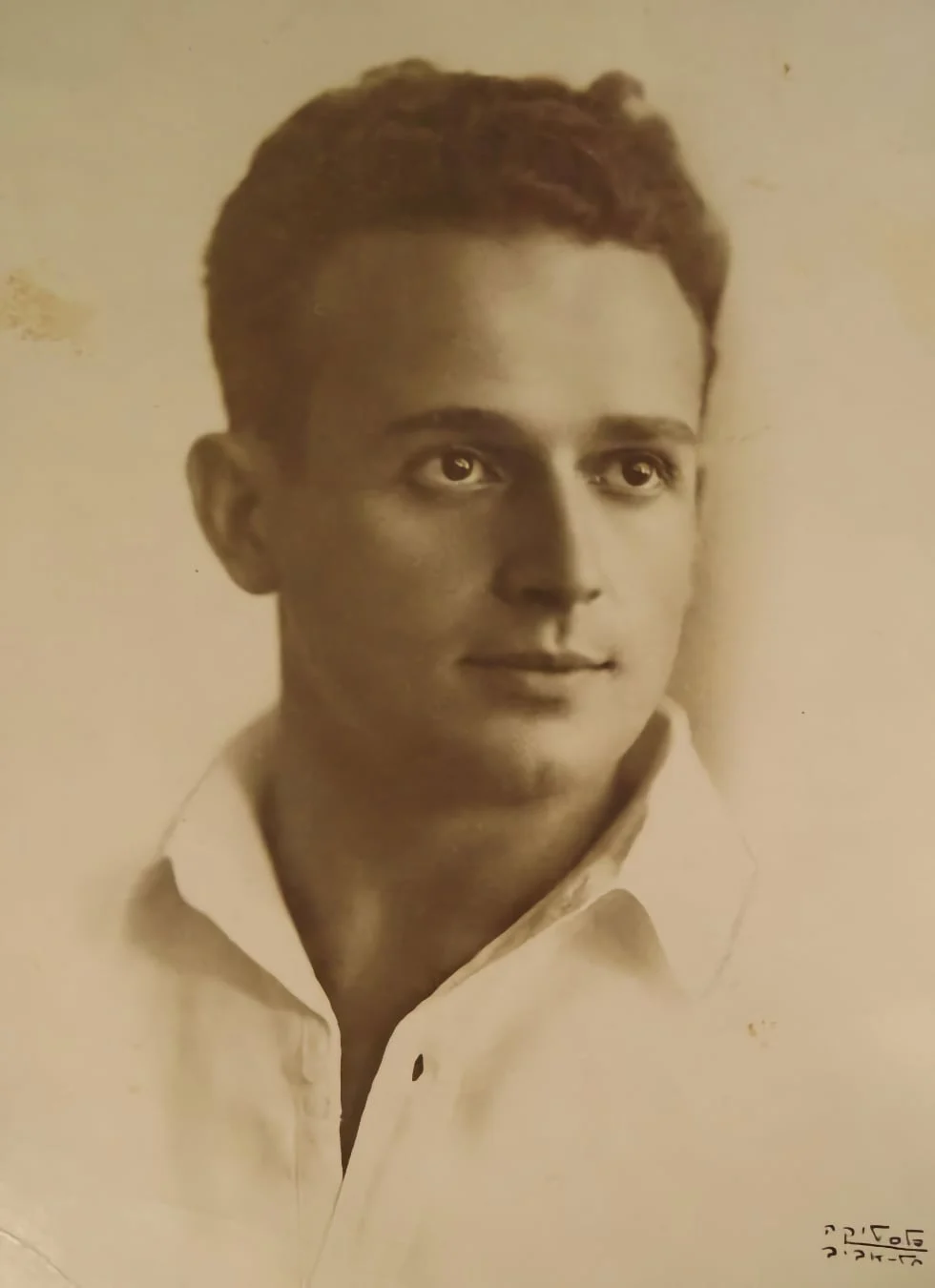 Studio portrait of Moshe Feldenkrais as a young man in an open-collared white shirt